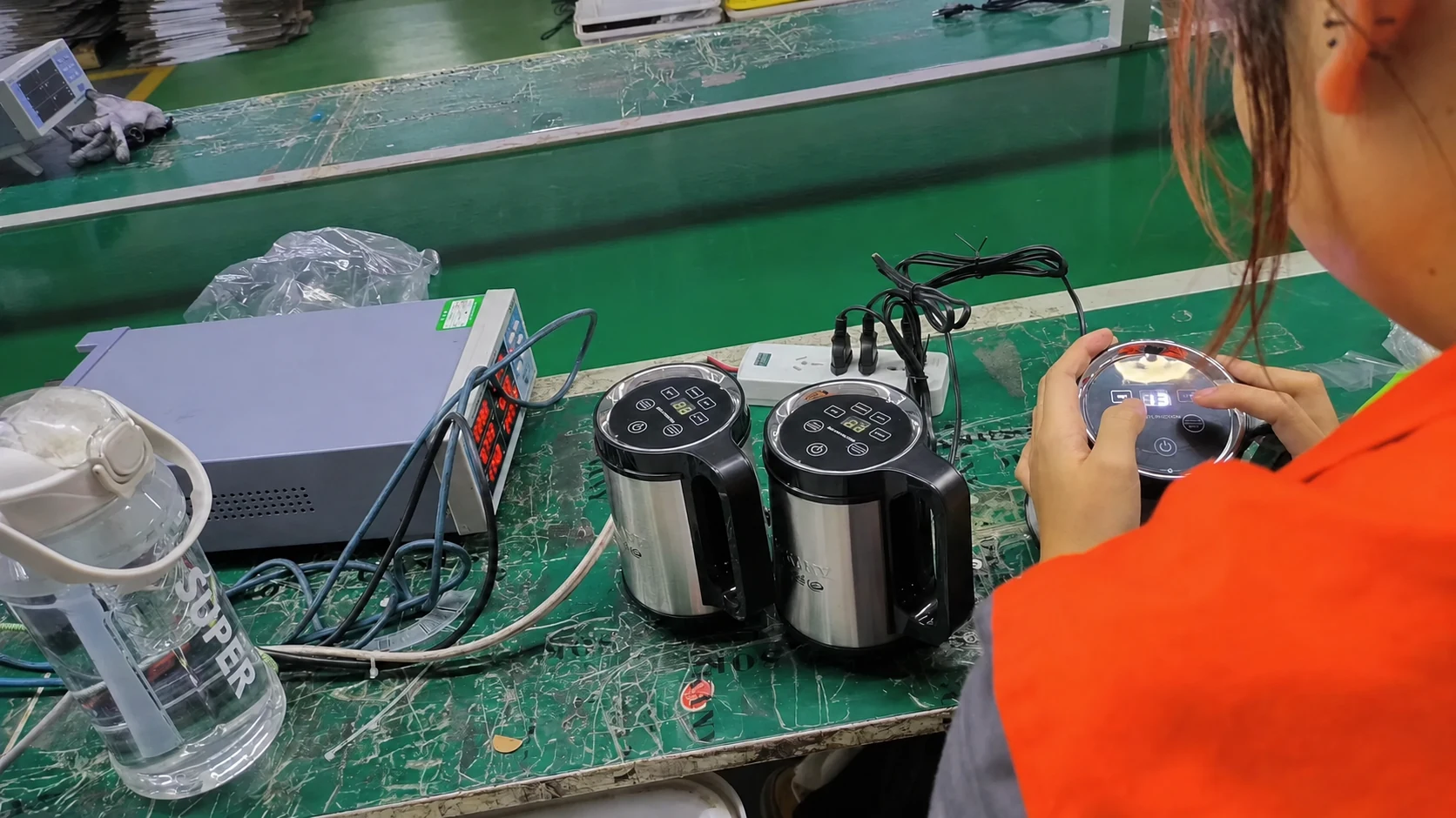 JINJIE worker checking small kitchen appliance motor units on the production line