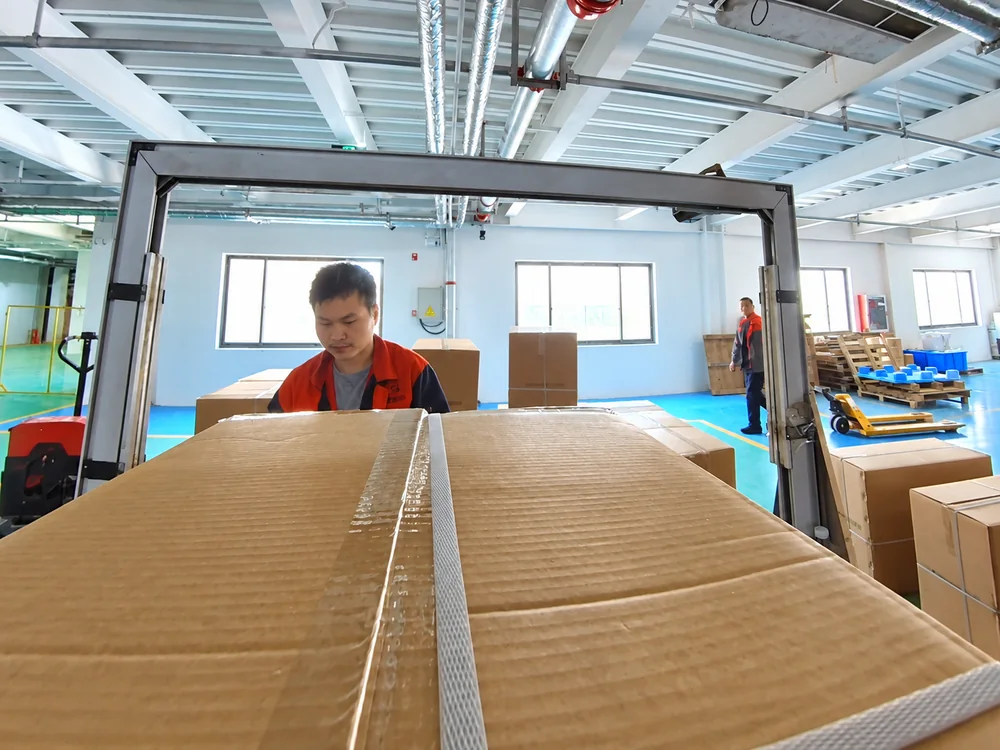 A carton in front of the strapping-machine arch in JINJIE's packing area