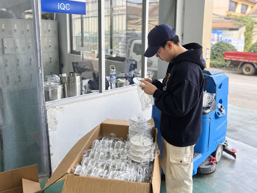 Worker examining a component beside an open box of parts at the JINJIE incoming inspection area