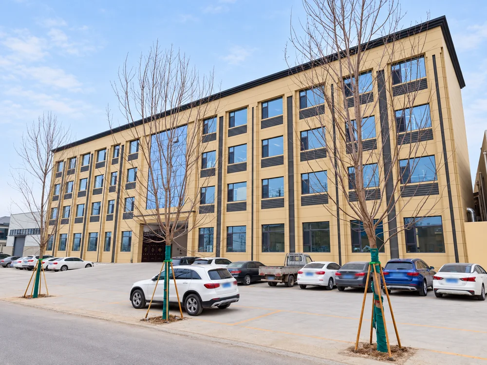 JINJIE factory building with beige walls, blue windows and a paved courtyard