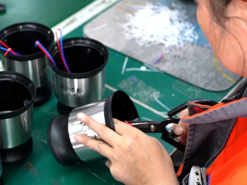 Wiring work inside a motor housing on the assembly line.