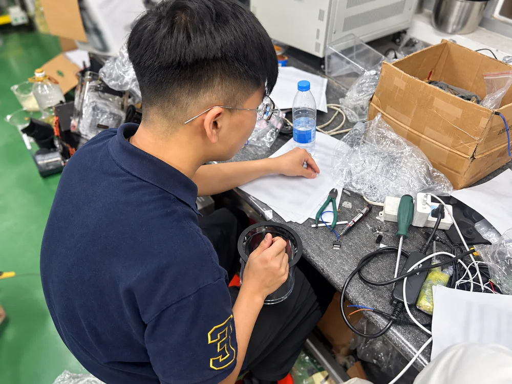 Technician reviewing a component and papers at a workbench