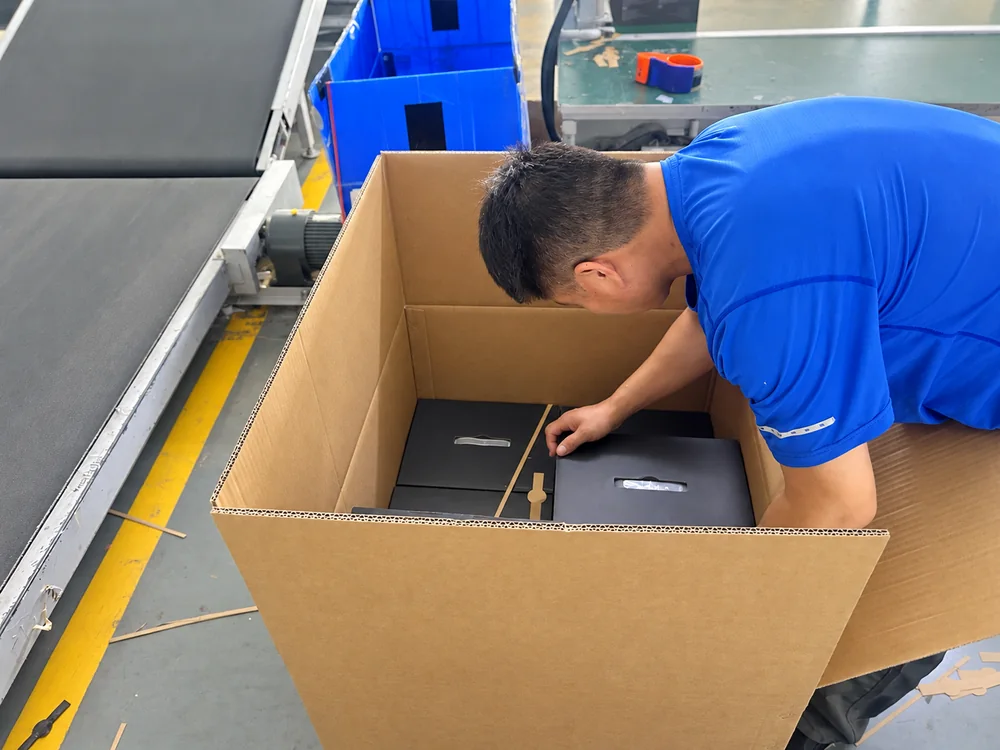Worker placing retail boxes inside a master carton