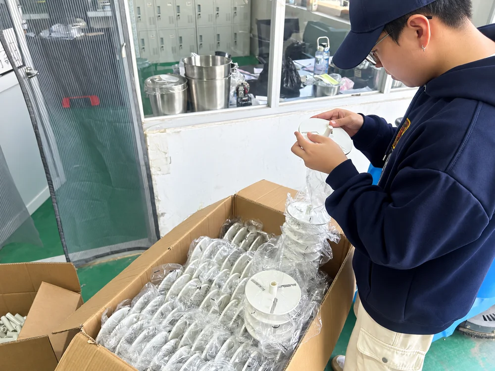 Worker examining a blade assembly beside bagged components