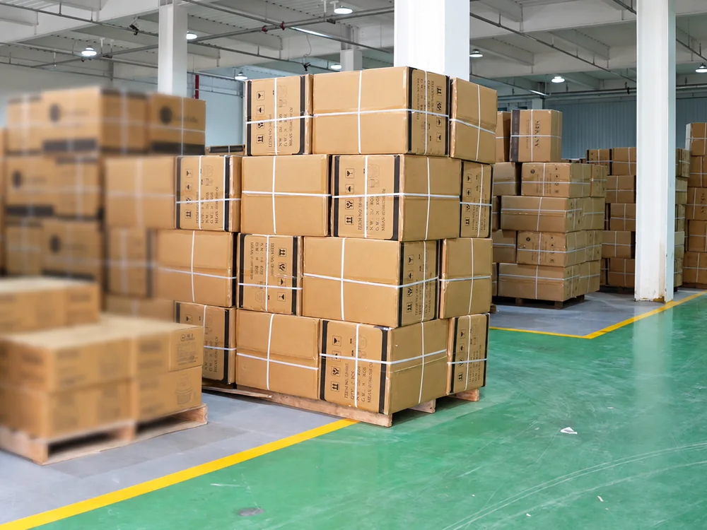 Strapped shipping cartons on pallets beside the aisle in JINJIE's warehouse