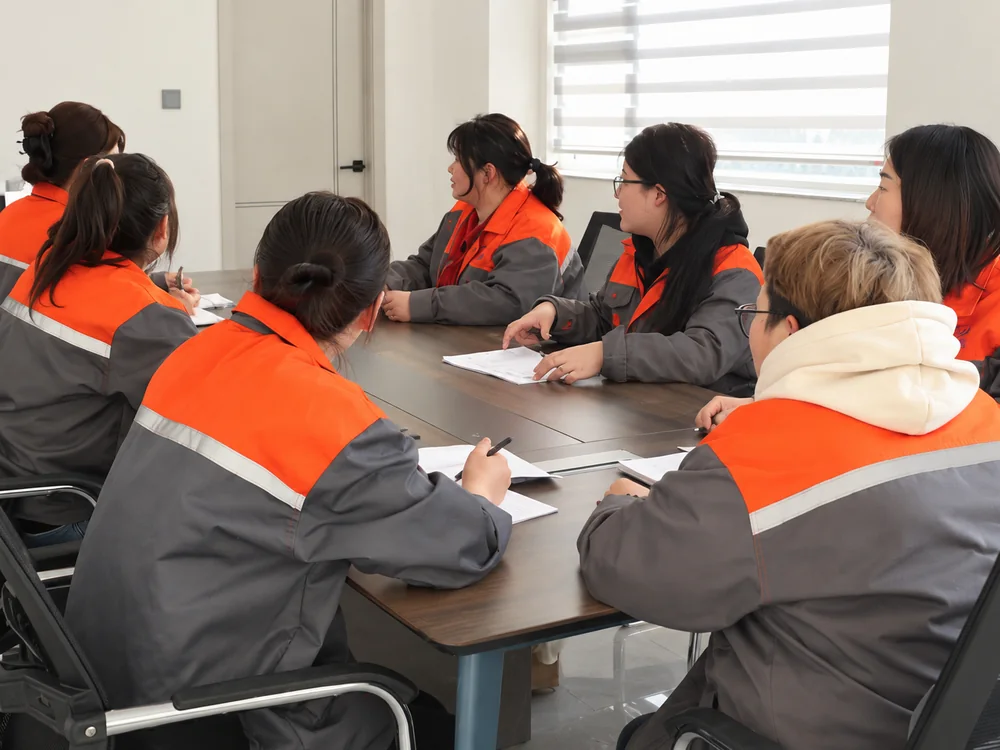 Factory team discussing production information around a meeting table