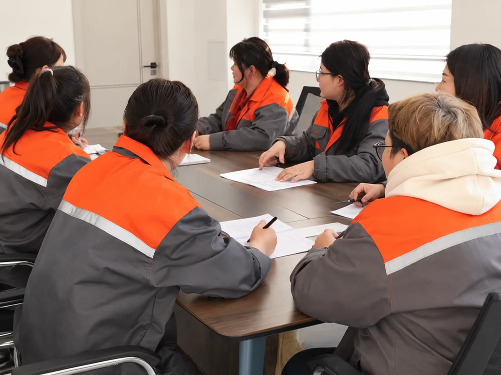 Factory colleagues discussing papers around their meeting table