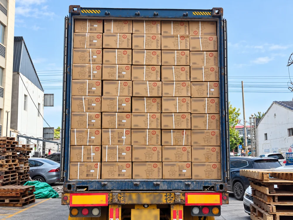 Real loaded freight container with stacked appliance cartons and customer information blurred