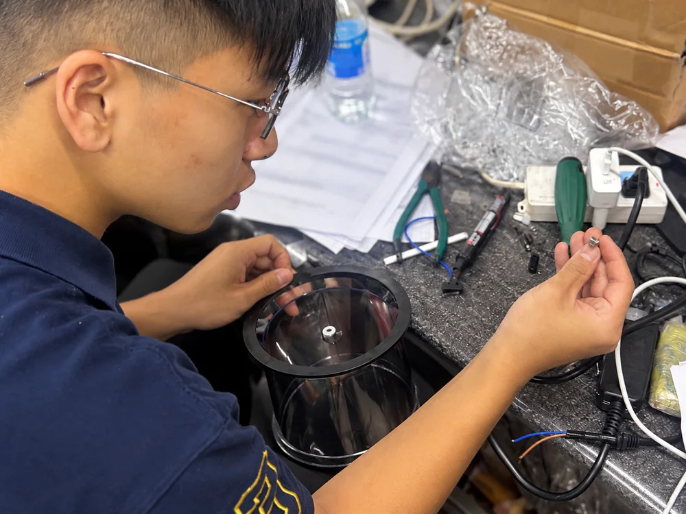 Close view of a technician examining a bowl component at a real appliance workbench